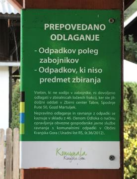 Informativna tabla, ki opozarja, da odlaganje odpadkov ob zabojnikih ni dovoljeno.